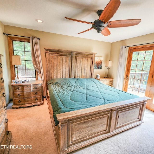 bedroom with multiple windows, access to outside, ceiling fan, and light colored carpet