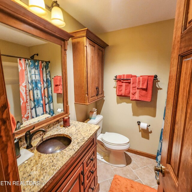 bathroom with tile patterned flooring, vanity, and toilet