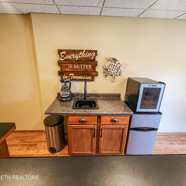 kitchen with hardwood / wood-style flooring, a paneled ceiling, and sink