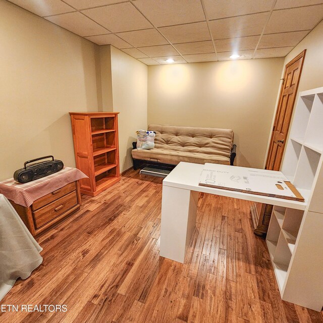 home office featuring a paneled ceiling and light hardwood / wood-style floors