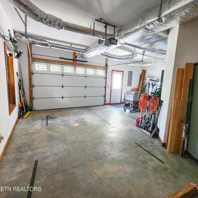 garage with a garage door opener and electric panel