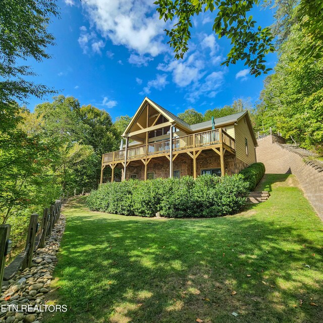 back of house with a wooden deck and a yard