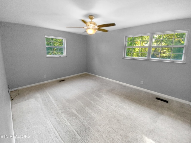 carpeted empty room featuring ceiling fan and a healthy amount of sunlight