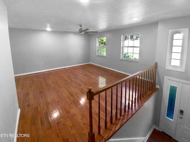 stairway featuring a textured ceiling and hardwood / wood-style flooring