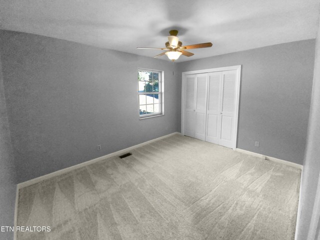 unfurnished bedroom featuring ceiling fan, a closet, and carpet