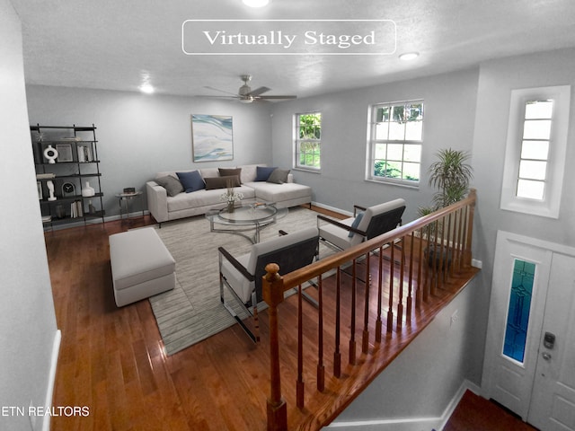 living room with ceiling fan, dark wood-type flooring, and a textured ceiling