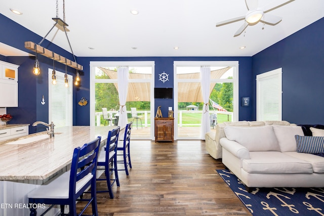 living room featuring ceiling fan, dark hardwood / wood-style floors, and sink