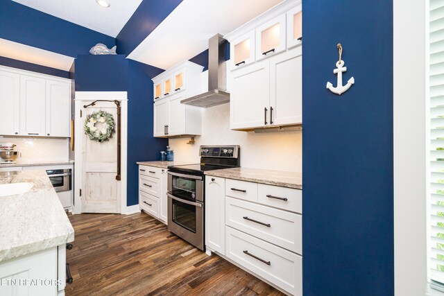 kitchen featuring white cabinetry, appliances with stainless steel finishes, wall chimney exhaust hood, and dark hardwood / wood-style floors