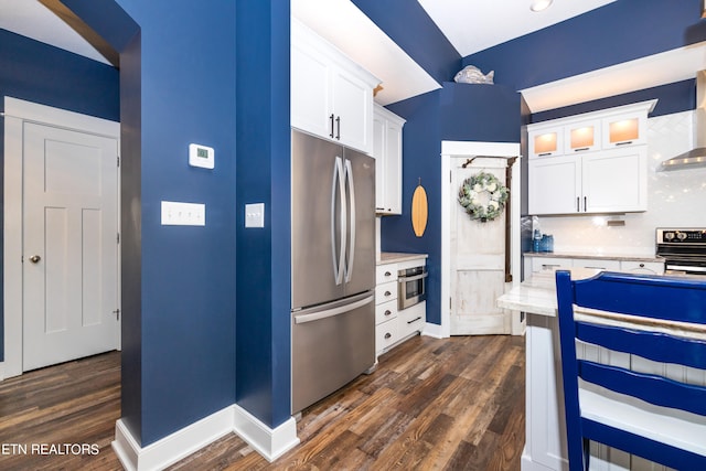 kitchen featuring stainless steel appliances, wall chimney exhaust hood, backsplash, white cabinets, and dark hardwood / wood-style flooring