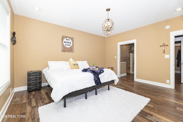 bedroom featuring dark hardwood / wood-style floors and an inviting chandelier