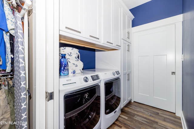 washroom with dark wood-type flooring, washing machine and dryer, and cabinets