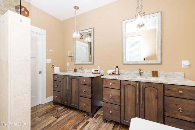 bathroom with a chandelier, vanity, and wood-type flooring