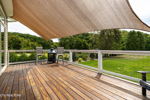 wooden terrace featuring a lawn