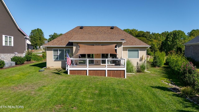 rear view of house featuring a lawn and a wooden deck