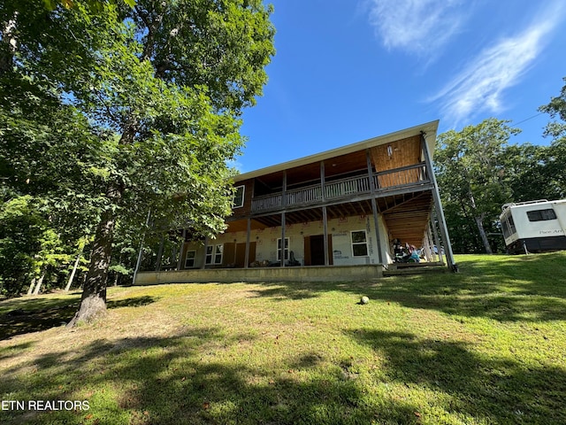 back of property featuring a lawn and a balcony