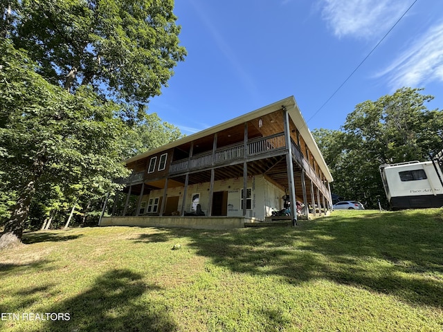 rear view of house featuring a lawn and a wooden deck