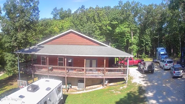 exterior space featuring aphalt driveway, a front yard, and roof with shingles