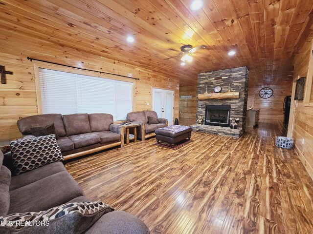 living room with wood ceiling, a fireplace, hardwood / wood-style floors, and ceiling fan