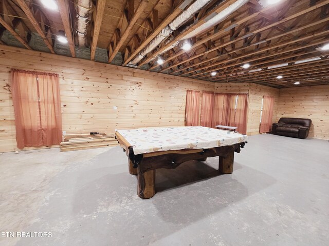 recreation room featuring billiards, wooden walls, and concrete floors