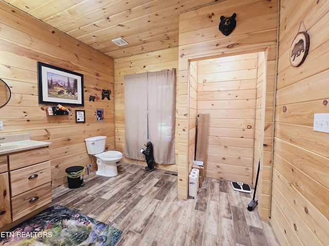 bathroom featuring toilet, wooden ceiling, wood walls, and wood finished floors