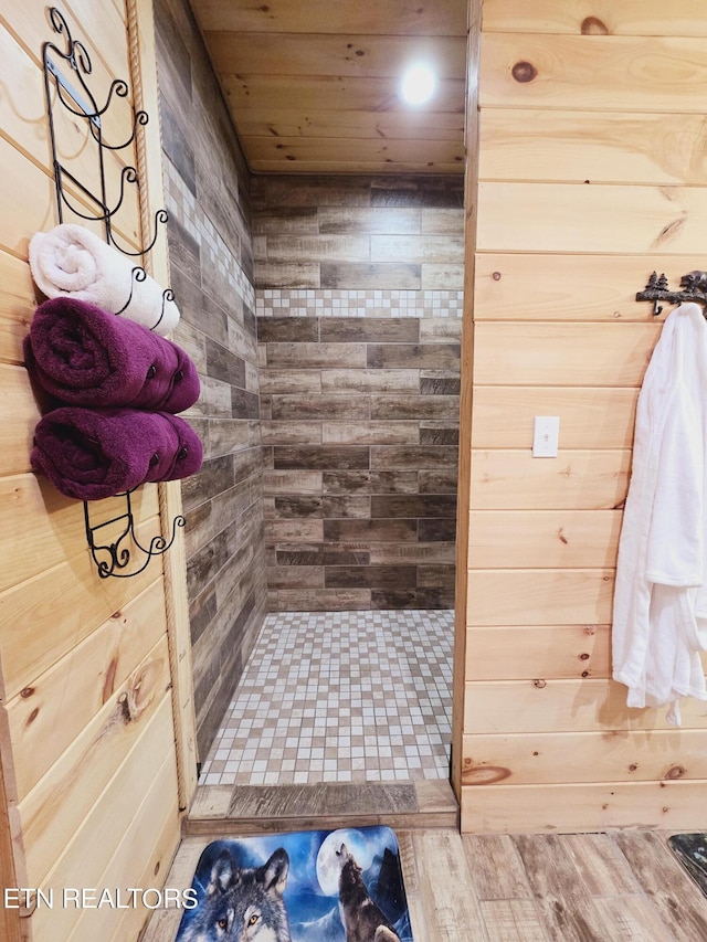 bathroom featuring a shower stall, wooden walls, wood finished floors, and wooden ceiling