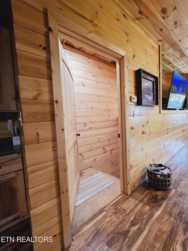 room details with wood walls and hardwood / wood-style flooring