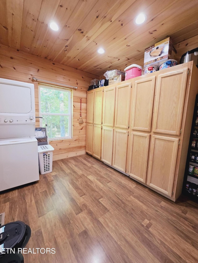 interior space featuring wooden ceiling, cabinet space, light wood-style floors, and stacked washer / drying machine