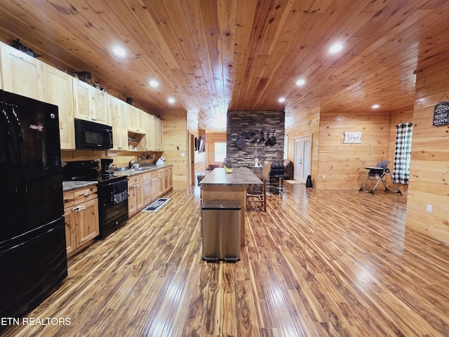 kitchen with wooden ceiling, a sink, wood walls, black appliances, and light wood-style floors