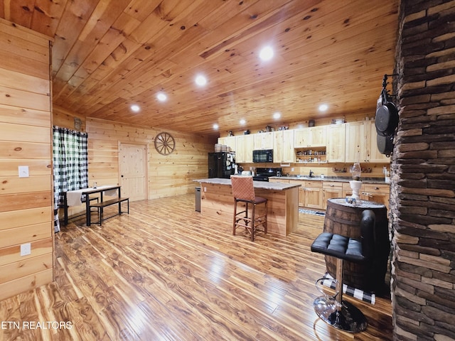 kitchen with a kitchen bar, a kitchen island, wood ceiling, light wood finished floors, and black appliances