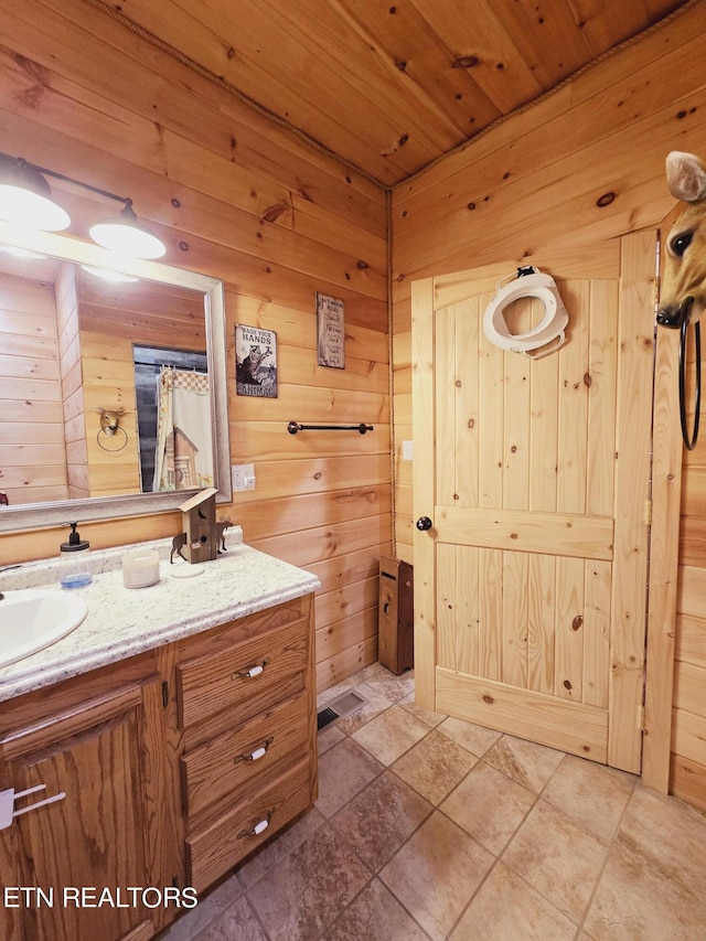 full bath featuring wooden walls, wooden ceiling, and vanity
