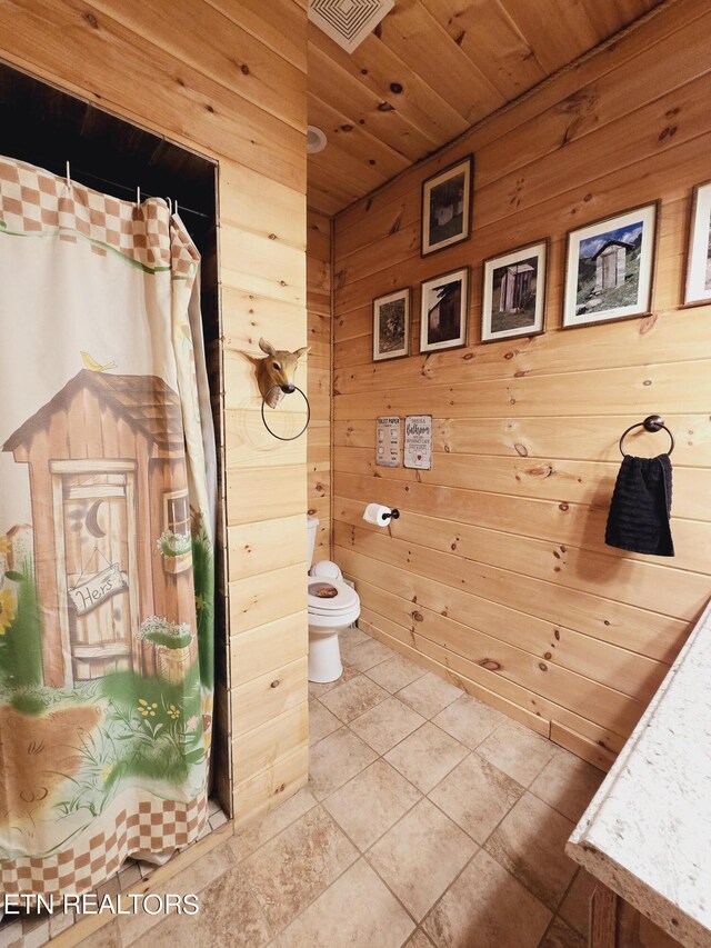 bathroom with wooden walls, wooden ceiling, curtained shower, and toilet