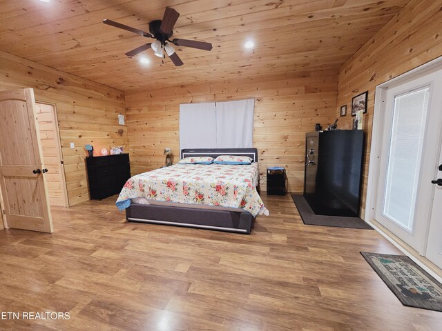 bedroom featuring light wood-type flooring, wood ceiling, wooden walls, and ceiling fan