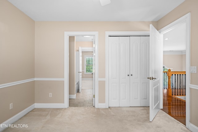 unfurnished bedroom featuring light carpet and a closet