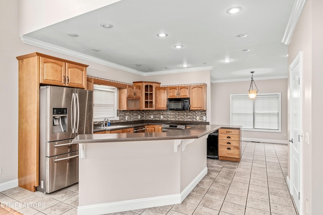 kitchen with light tile patterned floors, a kitchen island, backsplash, appliances with stainless steel finishes, and crown molding