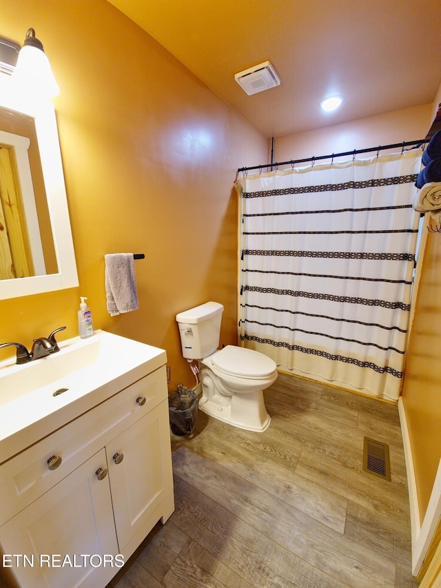 bathroom featuring vanity, hardwood / wood-style flooring, curtained shower, and toilet