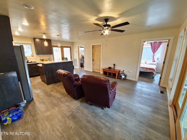 living room with ceiling fan and light hardwood / wood-style flooring