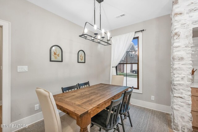 dining area featuring carpet and a notable chandelier