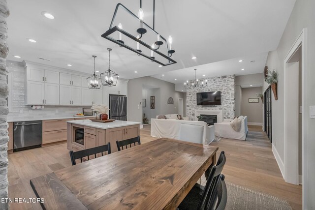 dining area featuring light hardwood / wood-style flooring and a large fireplace