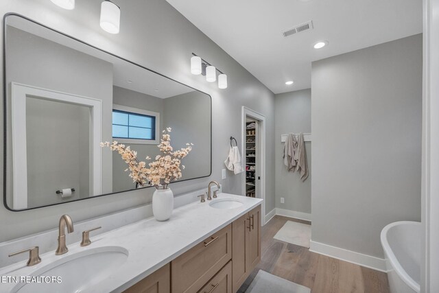 bathroom with vanity, hardwood / wood-style floors, and a tub