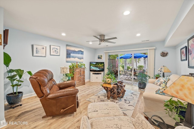 living room with light hardwood / wood-style floors and ceiling fan