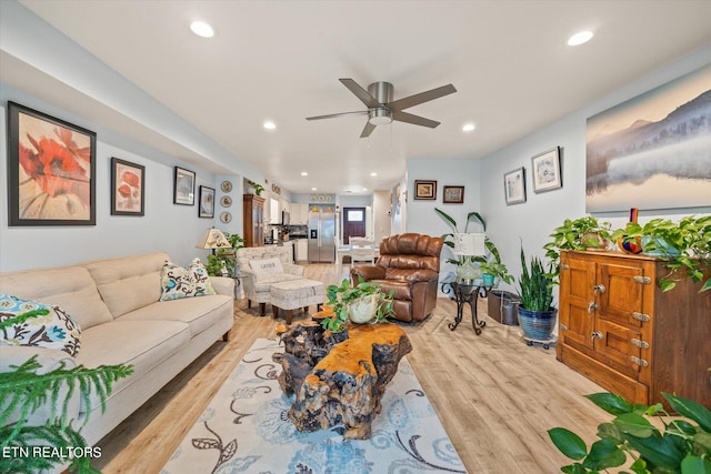 living room featuring ceiling fan and light wood-type flooring