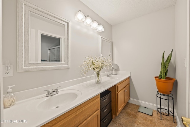 bathroom featuring a textured ceiling, vanity, tile patterned floors, and an enclosed shower