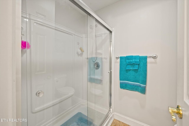 bathroom featuring walk in shower and toilet