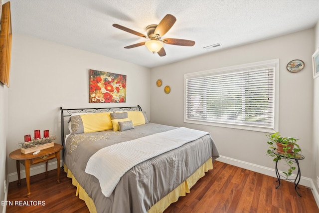 bedroom featuring a textured ceiling, dark hardwood / wood-style flooring, and ceiling fan