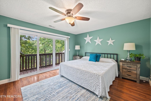 bedroom with a textured ceiling, dark hardwood / wood-style floors, ceiling fan, and access to exterior