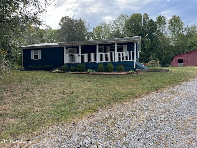 ranch-style home featuring a front lawn and covered porch