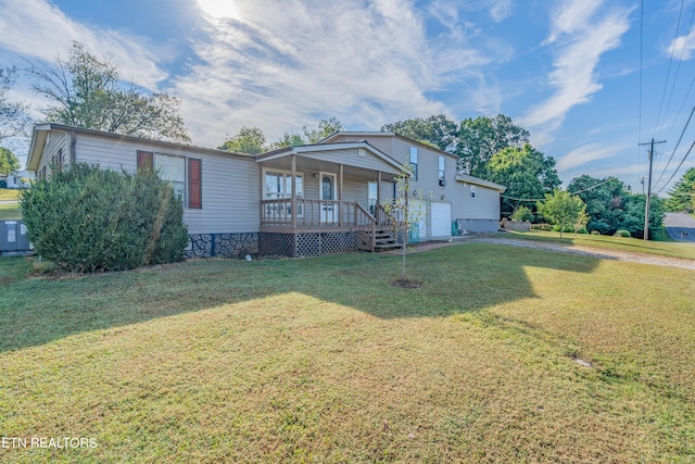 view of front of home with a front yard, a garage, and covered porch