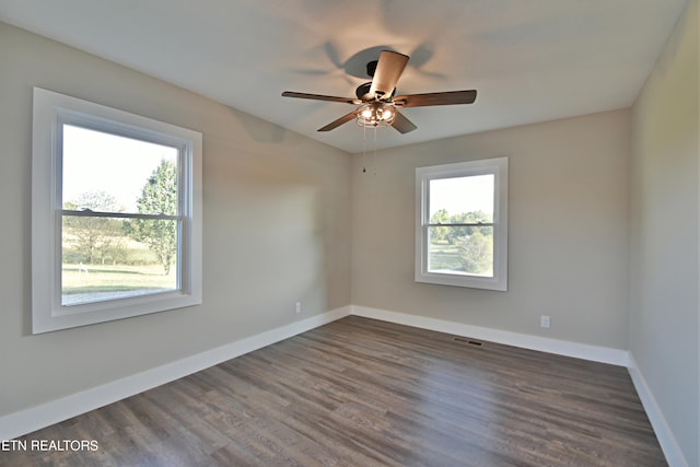 unfurnished room with ceiling fan, dark hardwood / wood-style floors, and a wealth of natural light