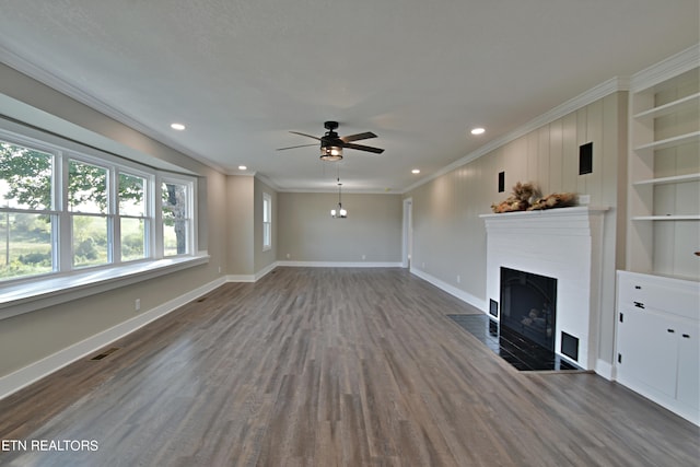 unfurnished living room featuring ornamental molding, built in shelves, ceiling fan, and dark hardwood / wood-style floors