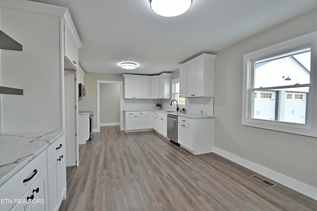 kitchen featuring light wood-type flooring, light stone counters, sink, white cabinetry, and stainless steel appliances